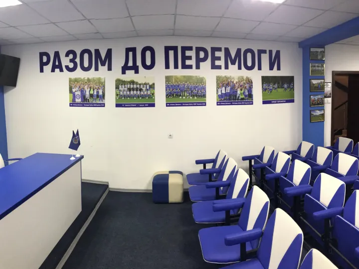 Ряди крісел для журналістів і гасло «Разом до перемоги»